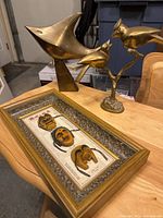 All three items grouped: brass swordfish, brass birds, framed mask display