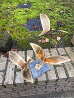 Front view of brass bird sculpture showing three birds and stone base