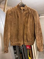 Front view of brown suede jacket on hanger