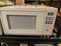 Front view of white Danby Diplomat microwave, closed door, digital keypad, LED display