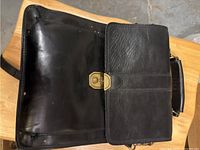 Front view showing flap and brass-tone turn-lock clasp