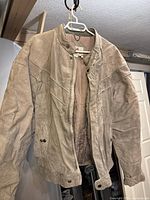 Full view of front of grey suede jacket hanging