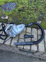 Full view of Shark handheld vacuum with hose and two attachments