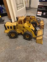 Two yellow Tonka Mighty Loader toys side by side