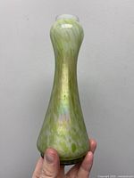 Full view showing vase profile, mottled green coloration and iridescence