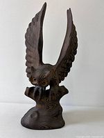 Front view of carved wood owl with raised wings and glass eyes