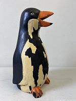 Front view of carved wood penguin with distressed paint
