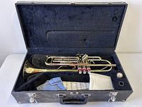 Trumpet in open case with cloths and sheet insert visible