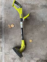 Full view of Ryobi 18V cordless string trimmer laying on floor