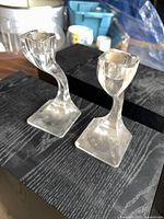 two clear glass twisted candlesticks front view