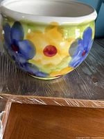 Front view of round ceramic plant pot with floral pattern