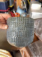 Front view of blue ceramic pot showing textured grid glaze