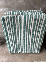 Folded green and white striped single mattress showing tri-fold construction