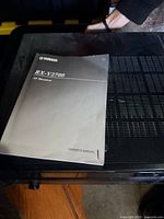 Top view showing Yamaha RX-V2700 manual resting on receiver