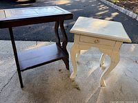 Dark brown wooden side table and white painted side table side-by-side