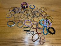 Overview of all bangles and stretch bracelets spread on wooden surface