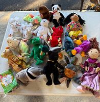 Full lot overview on table showing all plush animals and dolls