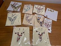 Overall view of nine packaged rhinestone jewelry sets on table