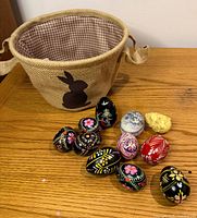 Overall lot showing basket and eight painted eggs on tabletop