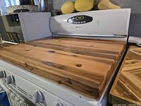 Full view of acacia wood stove cover on range