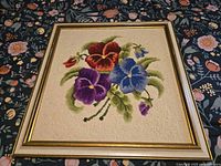 Front view of framed latch hook pansy art showing full design and frame