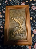 Front view showing carved sailfish plaque in frame