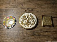 Front view of three compacts closed, showing exterior designs