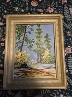 Framed vertical oil painting showing forest scene