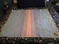 Full view of blanket laid flat showing color stripes and fringe