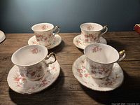 Four matching teacup and saucer sets displayed on tabletop