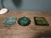 Three ashtrays grouped: light teal diamond, emerald round, olive square