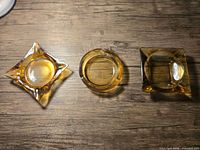 Overhead view of three amber glass ashtrays showing shapes
