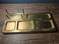 Top view of brass valet tray showing labeled compartments and wire rails