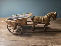Side profile of brass horse and buggy