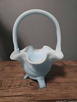 Front view showing handle, ruffled rim and feet