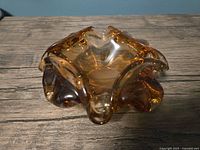 Top view of amber art glass ashtray showing lobed rim and central bowl