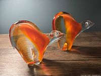 Two solid glass bear figurines side by side, frontal angle highlighting internal colour