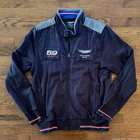 Front view of navy Aston Martin Racing by Hackett jacket showing chest patches and overall condition