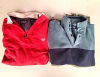 Both sweaters folded, showing colors, logo and collars
