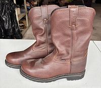 Left side view of both boots showing leather texture, sole condition, pull tabs