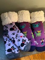 Two pairs Pudus slipper socks side by side showing colours and designs