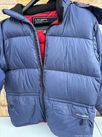 Front view showing navy exterior, red lining, full zip, pockets