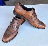 Side and top view of both shoes showing overall condition and brogue detailing