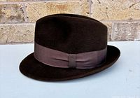 Side view of brown felt fedora with grosgrain hatband