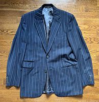 Front view of navy pinstripe Hermès blazer showing two-button closure, notch lapel, pockets, and lining