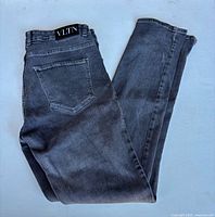 Full view of jeans folded showing back pocket and VLTN patch