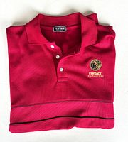Folded red Versace Jeans Couture polo shirt showing collar, buttons, embroidery, piping