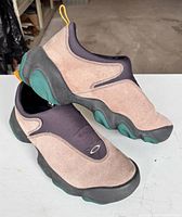 Side view of both Oakley Flesh slip-on shoes showing suede, neoprene, and green outsole pods.