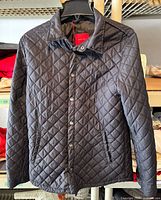 Full front view of quilted jacket on hanger