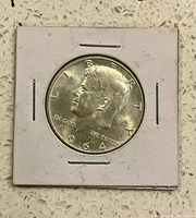 Obverse of 1964 Kennedy half dollar in flip holder
